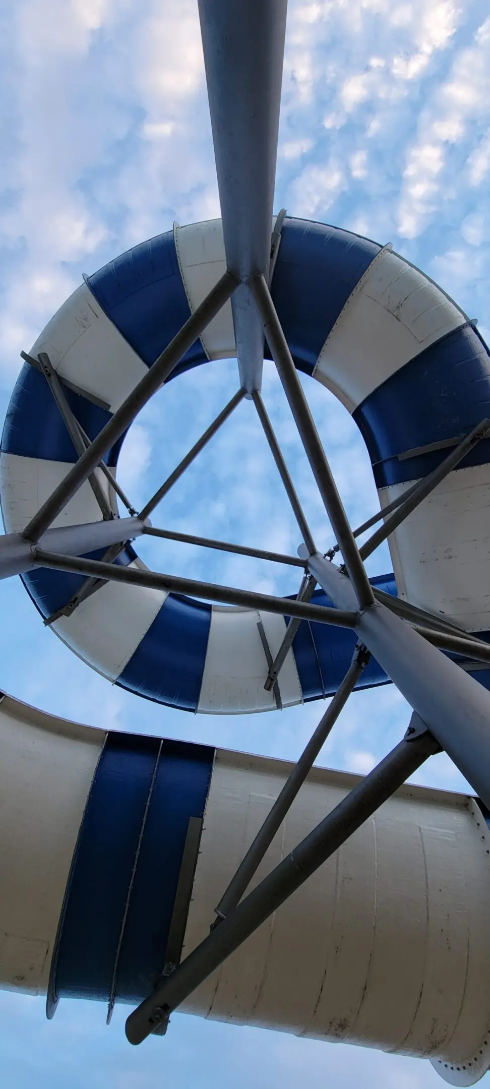 View through a blue and white lifebuoy with sky in the background.